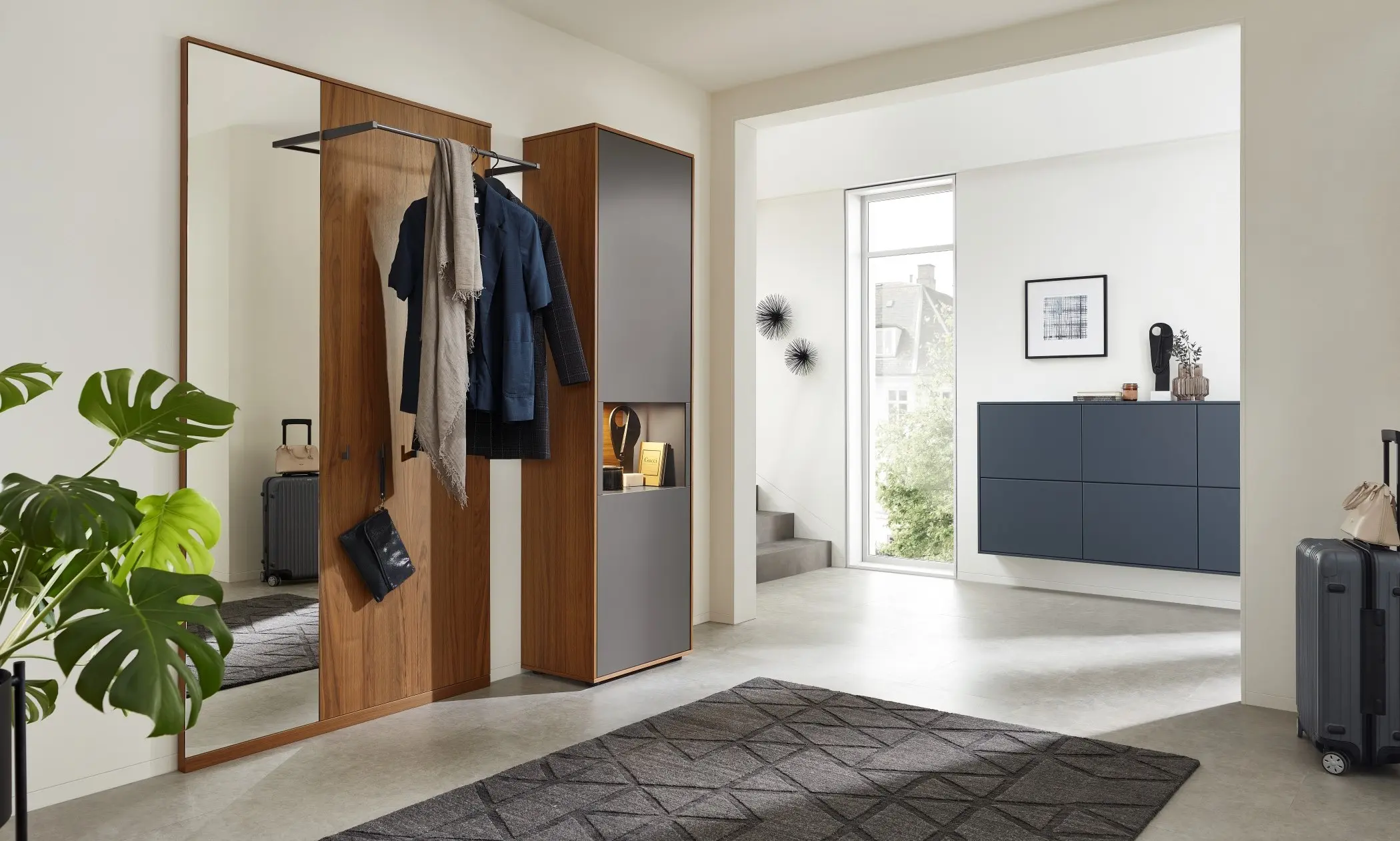 Face Garderobe, zu sehen Ganzkörperspiegel mit Garderobenpaneel aus Holz mit Vitrinenelement für Schuhe und Kommode hängend